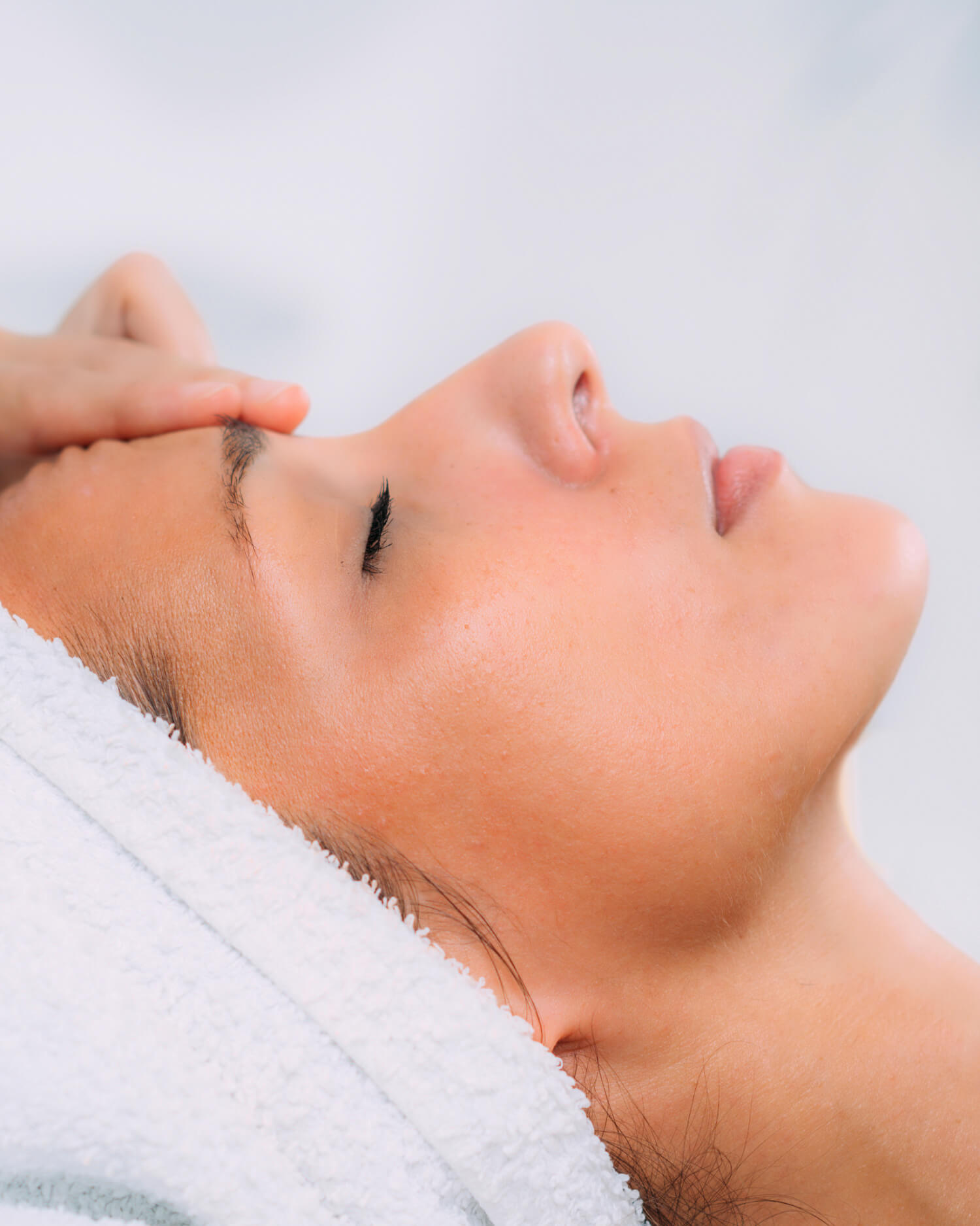 Woman having facial mask applied by brush.