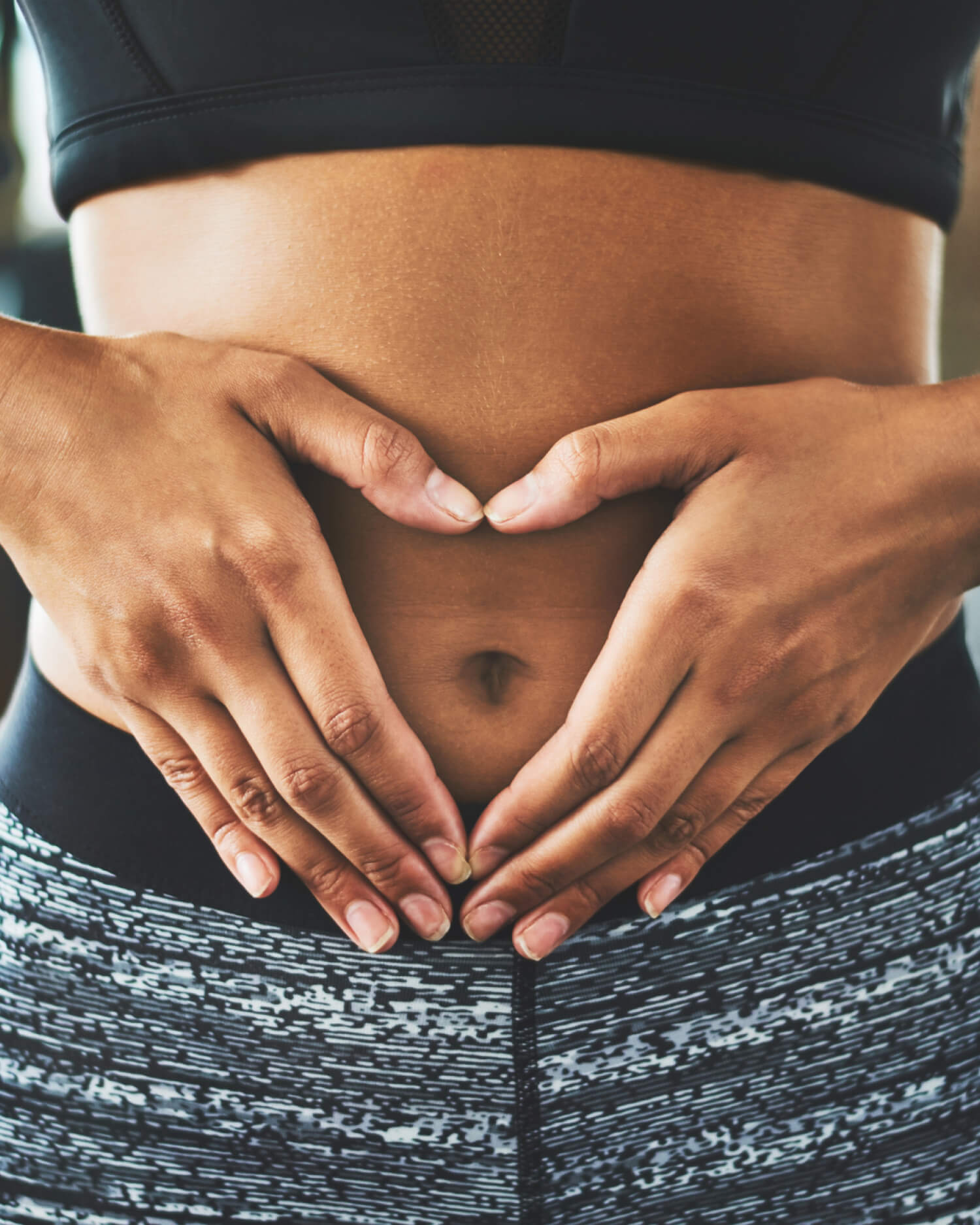 A woman holding her hands over her stomach