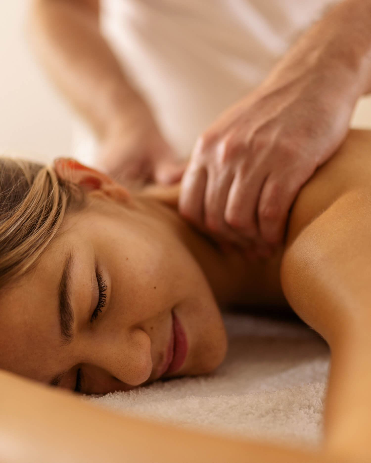 Woman lying on her stomach, receiving a massage.