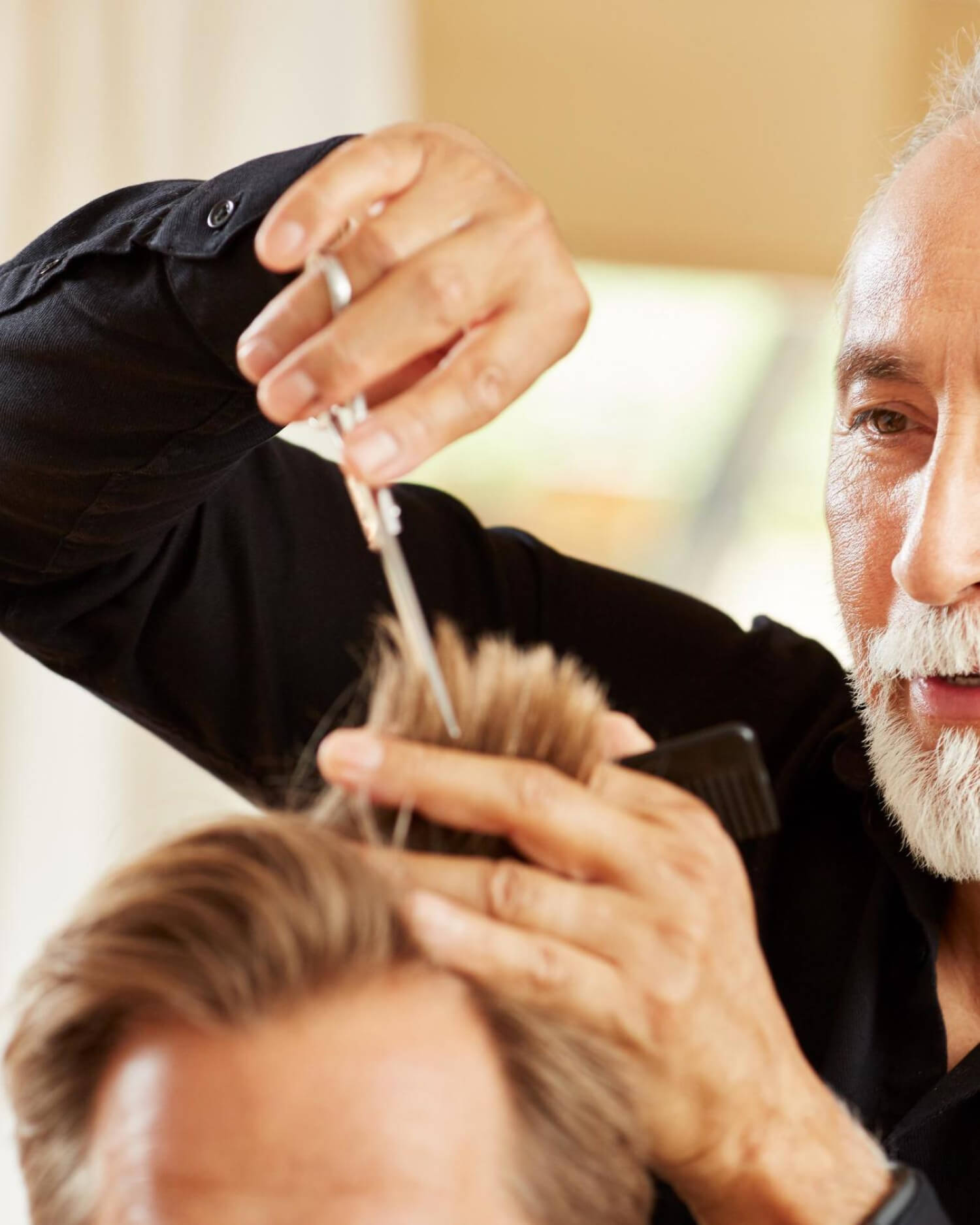Man receiving haircut with comb and clippers.