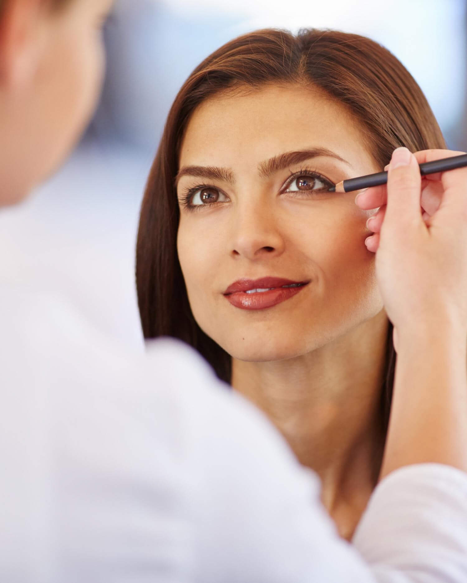 Woman receiving makeup application.