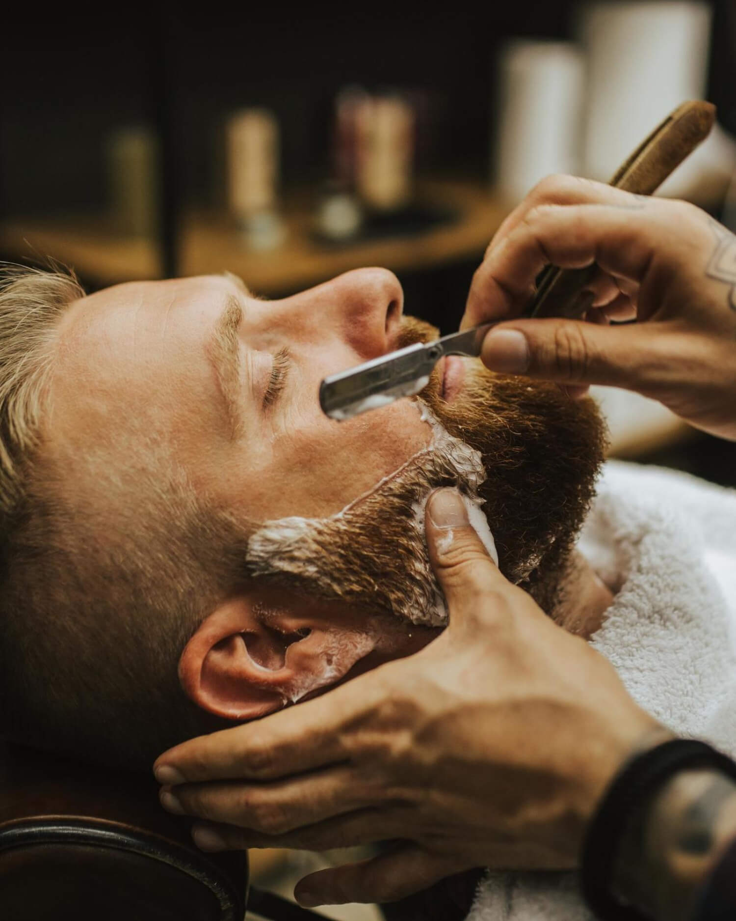 A man receiving a straight razor shave.