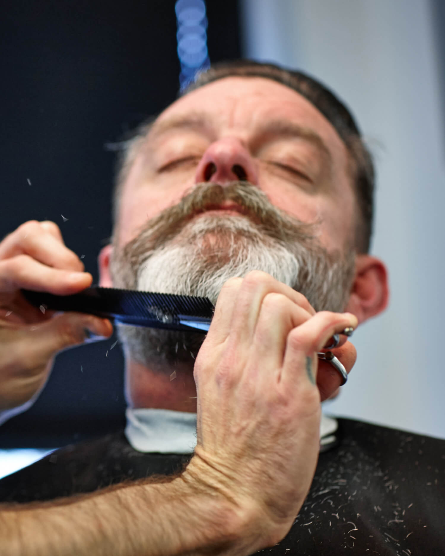 A man getting his beard trimmed