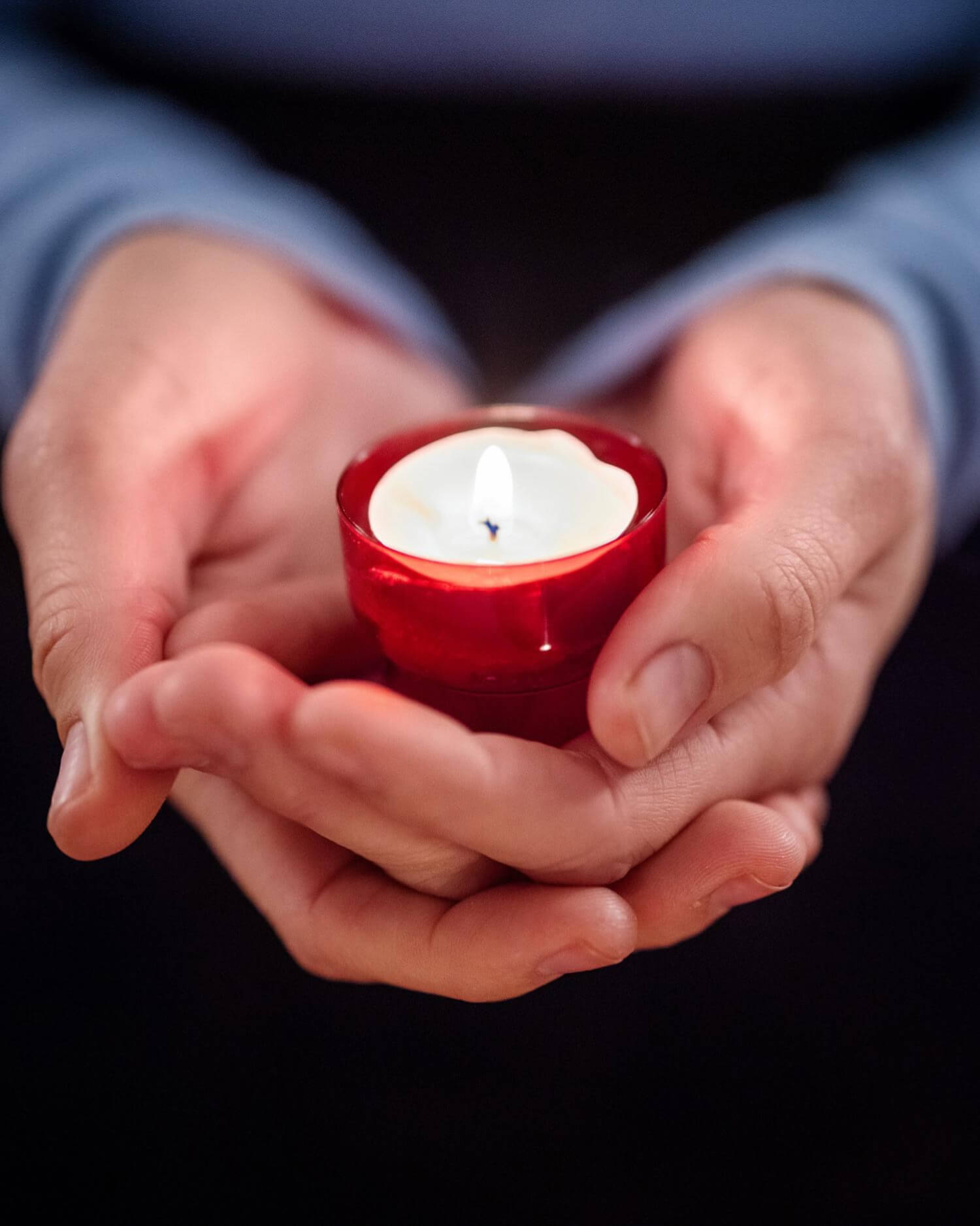 Pair of hands holding a candle