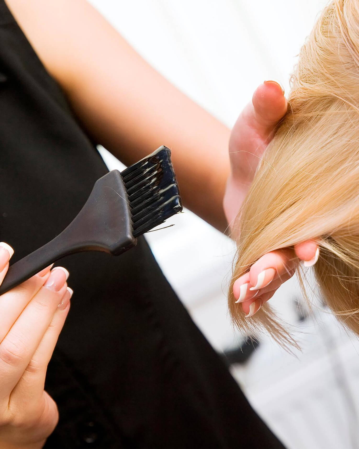 Woman having hair color brushed on